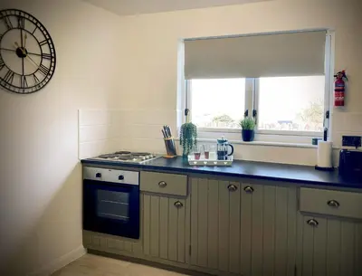 a kitchen with a stove and a clock on the wall at Penkenna in Bude