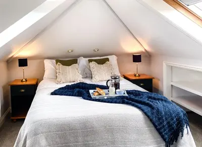 a bedroom with a bed with a blue blanket on it at Penkenna in Bude