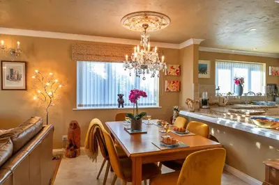 a dining room and kitchen with a table and a chandelier at Finest Retreats - Harvest Moon in Newquay