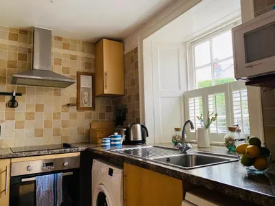 a kitchen with a sink and a dishwasher at Maypole Cottages No 10 Broad Street Padstow in Padstow