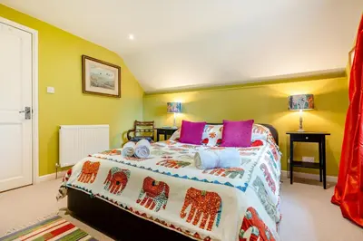 a bedroom with a large bed with colorful pillows at 2 Bed in St. Mawgan oc-l30651 in Saint Mawgan
