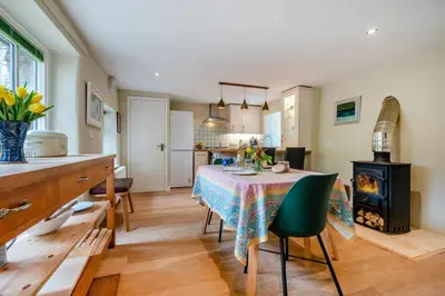a kitchen and dining room with a table and a stove at 2 Bed in St. Mawgan oc-l30651 in Saint Mawgan