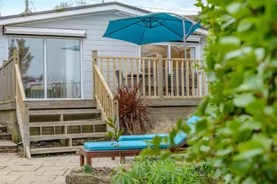 a patio with a bench and an umbrella at 2 Bed in Mawgan oc-c30671 in Mawgan