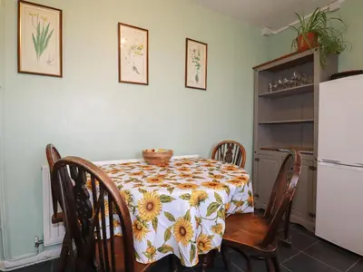a kitchen with a table and chairs and a refrigerator at Bramble Cottage in Hayle