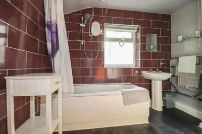 a bathroom with a tub and a sink at Bramble Cottage in Hayle