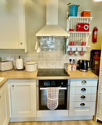 a kitchen with white cabinets and a stove top oven at Apartment in Constantine in Constantine