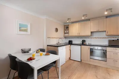 a kitchen and dining room with a table and chairs at 7 Lower Talland Apartments in St Ives