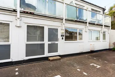 a white building with large windows on the side of it at 7 Lower Talland Apartments in St Ives