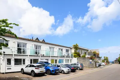 a row of cars parked in front of a building at 7 Lower Talland Apartments in St Ives