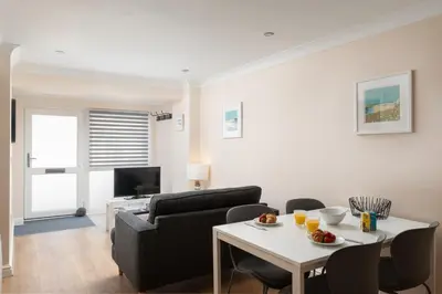 a living room with a couch and a table at 7 Lower Talland Apartments in St Ives