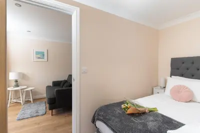a bedroom with a large bed and a mirror at 7 Lower Talland Apartments in St Ives