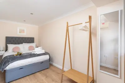 a bedroom with a bed and a mirror at 7 Lower Talland Apartments in St Ives