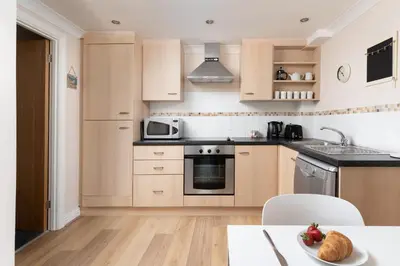 a kitchen with a sink and a stove top oven at 6 Lower Talland Apartments in St Ives