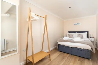 a bedroom with a bed and a mirror at 6 Lower Talland Apartments in St Ives