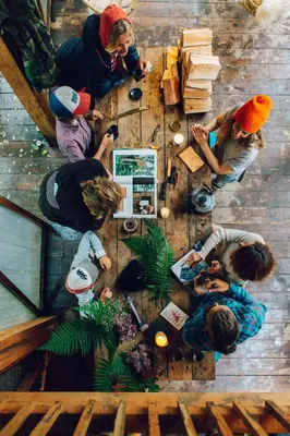 a group of people sitting around a wooden table at Kudhva 2 in Treknow