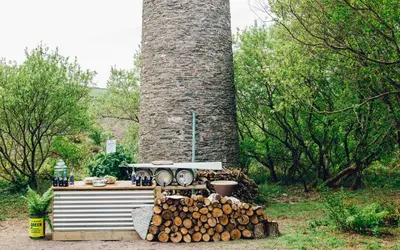 a stack of logs in front of a large chimney at Kudhva 2 in Treknow