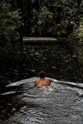 a man swimming in a body of water at Kudhva 2 in Treknow