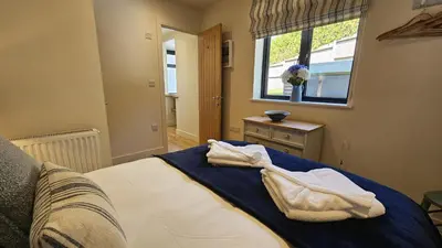 a bedroom with a bed with two towels on it at Chupra in Saint Mawes