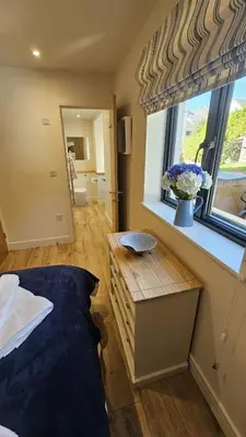 a bedroom with a bed and a window at Chupra in Saint Mawes