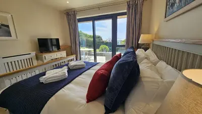 a bedroom with a bed with red pillows and a television at Chupra in Saint Mawes