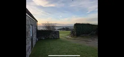 a view of a yard with a stone wall at Seaview Barns in Budock Water
