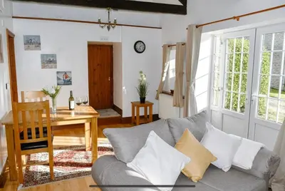 a living room with a couch and a table at Seaview Barns in Budock Water