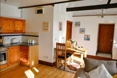 a kitchen with a table and a dining room at Seaview Barns in Budock Water