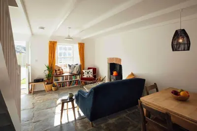 a living room with a blue couch and a table at Charming Cottage & Garden in Port Isaac in Port Isaac
