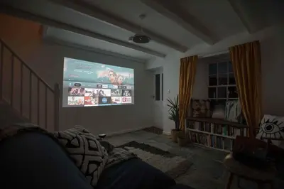 a living room with a large projection screen on the wall at Charming Cottage & Garden in Port Isaac in Port Isaac