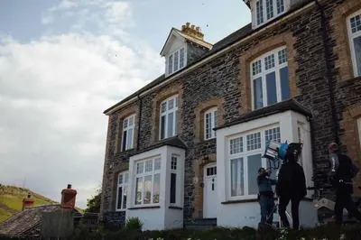 a group of people standing outside of a brick house at Charming Cottage & Garden in Port Isaac in Port Isaac