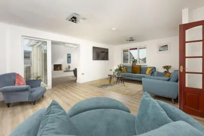 a living room with blue chairs and a couch at Ocean Parc in Carbis Bay