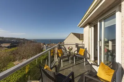 a balcony with chairs and a view of the ocean at Ocean Parc in Carbis Bay