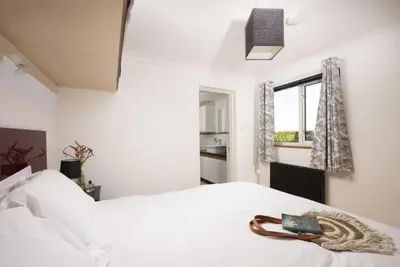 a bedroom with a white bed with a book on it at Ocean Parc in Carbis Bay