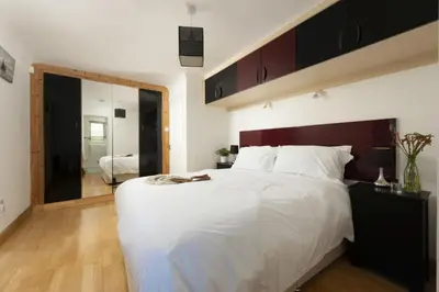 a bedroom with a large white bed and a mirror at Ocean Parc in Carbis Bay