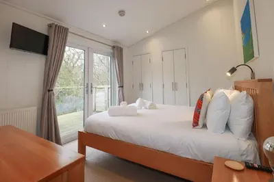 a bedroom with a bed and a large window at 1 Miller's Island in Looe