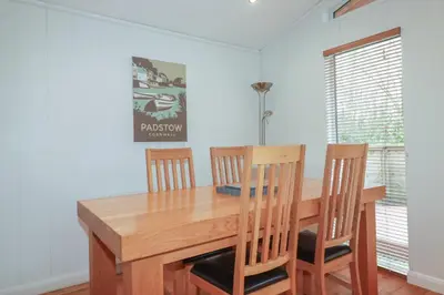 a dining room with a wooden table and chairs at 1 Miller's Island in Looe