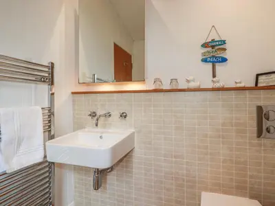 a bathroom with a sink and a mirror at 1 Miller's Island in Looe