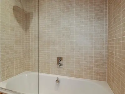 a bathroom with a tub with a glass shower at 2 Miller's Island in Looe