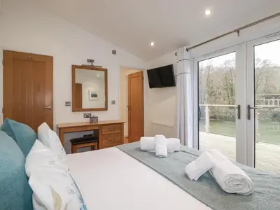 a bedroom with a bed and a large window at 2 Miller's Island in Looe