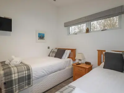 a bedroom with two beds and a window at 2 Miller's Island in Looe
