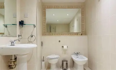 a bathroom with a sink and a toilet and a mirror at Hustyns Hotel in Wadebridge