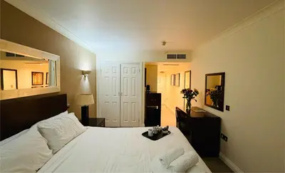 a bedroom with a white bed and a mirror at Hustyns Hotel in Wadebridge