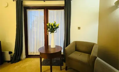 a room with a vase of flowers on a table and a chair at Hustyns Hotel in Wadebridge
