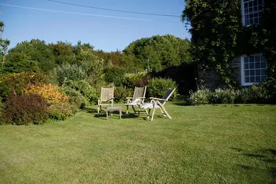 two chairs sitting in the grass in a yard at Roskear Farm in Wadebridge