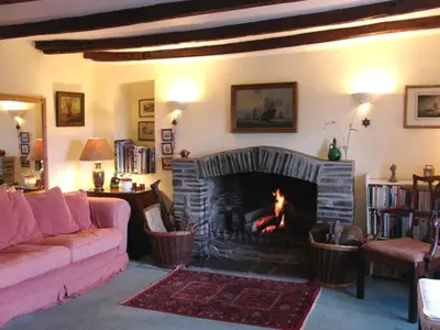 a living room with a fire in a fireplace at Roskear Farm in Wadebridge