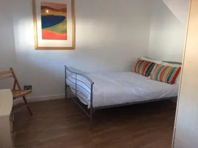a small bed in a room with a painting on the wall at 5 Hatfield Cresent in Newquay