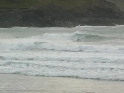 a group of surfers riding the waves in the ocean at 5 Hatfield Cresent in Newquay