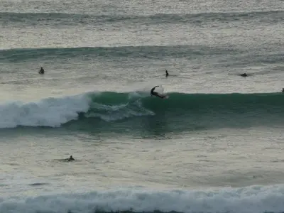a group of surfers riding a wave in the ocean at 5 Hatfield Cresent in Newquay