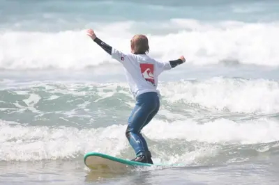 a man riding a wave on a surfboard in the ocean at 5 Hatfield Cresent in Newquay