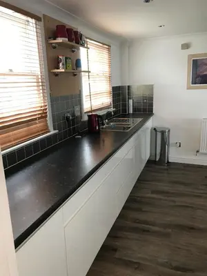 a kitchen with white cabinets and a black counter top at 5 Hatfield Cresent in Newquay